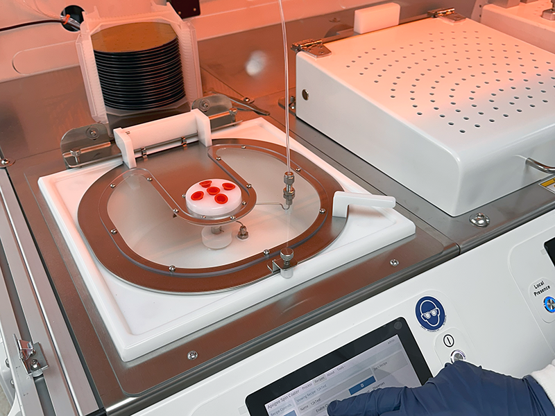A process engineer using a 200mm Apogee® Spin Coater that is installed in a Cee® X-Pro II Workstation.