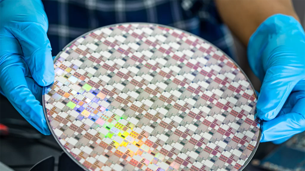 An operator holding a patterned silicon wafer.