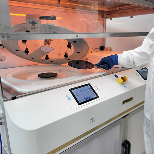 A semiconductor process engineer using an Apogee® 450 Spin Coater that is installed in a Cee® X-Pro II Workstation.